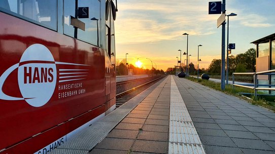 Das Foto zeigt einen Zug des Verkehrsunternehmens HANS an einem Bahnsteig