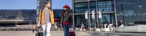 Unterwegs im Sommer Paar mit Rollkoffern vor Berliner Hauptbahnhof