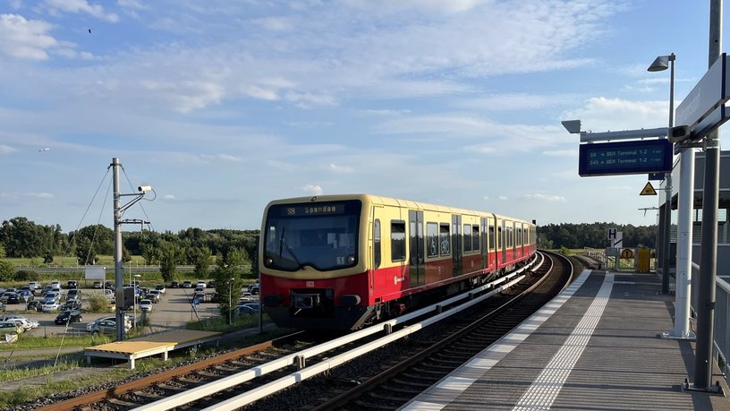 Blick auf eine S9 Richtung Spandau vorbeifahrend am Bahnhof Waßmannsdorf