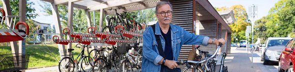 Fahrradmitnahme Mann mit Fahrrad an Fahrradabstellanlage