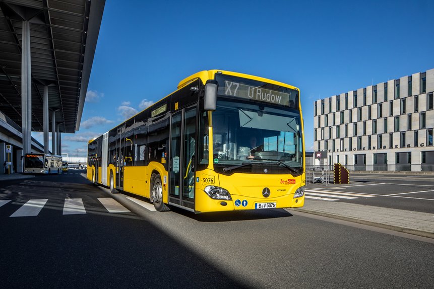 Das Foto zeigt einen gelben Bus der BVG am Flughafen BER.