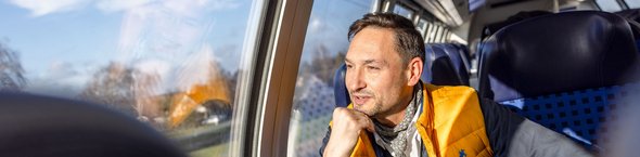 Abonnements Mann in Regionalbahn am Fensterplatz